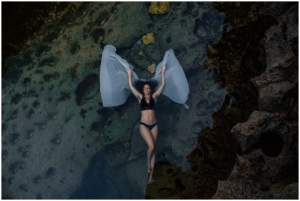 Beautiful woman floating in water with angel wings