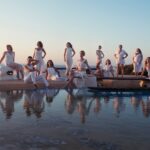 Group photo of women in white by a pool in Greece