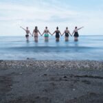 Group of women holding hands in the water