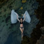 Beautiful photo of woman floating in the water at bali photo location Angel's Billabong